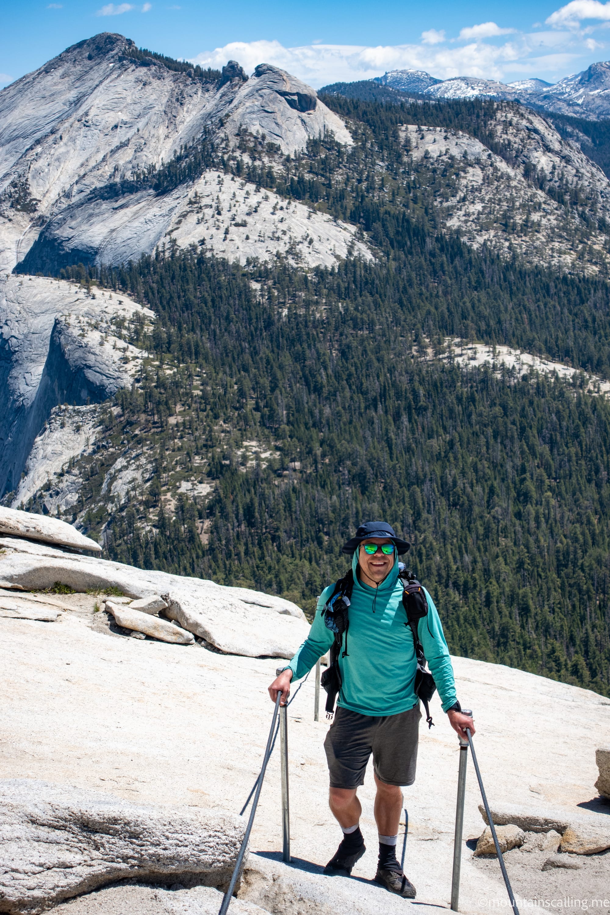 MountainsCalling.me Yosemite Guide Eric Kufrin on the Half Dome Cables in Yosemite, beyond is the expansive wilderness of the High Sierra.
